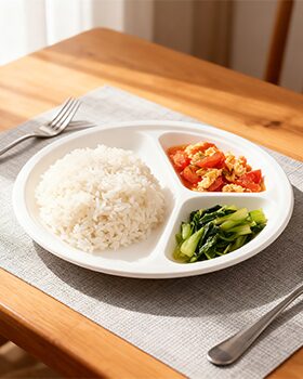 Compartment fast food box with rice and vegetables on a wooden table