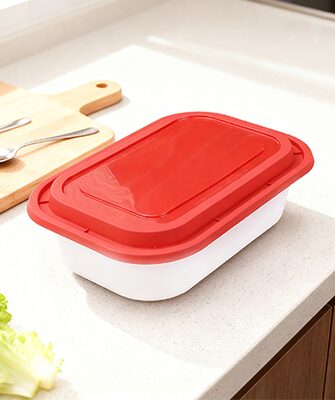 Meat and fresh food container with red lid on a kitchen counter